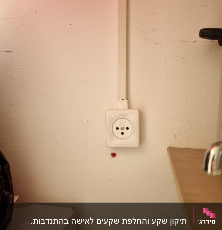 שקע חשמל על קיר עם כבל חשמל